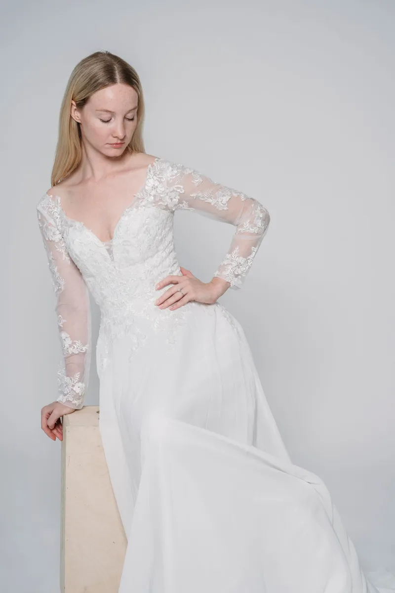 A-line gown with long lace sleeves and a plunging neckline