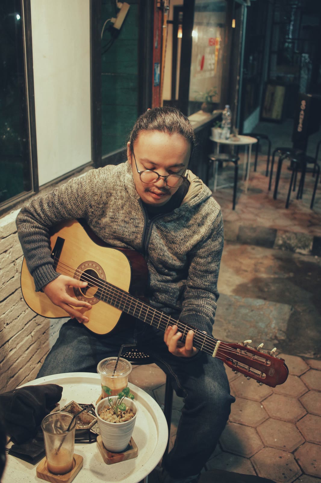Guitarist playing at a café table in the evening