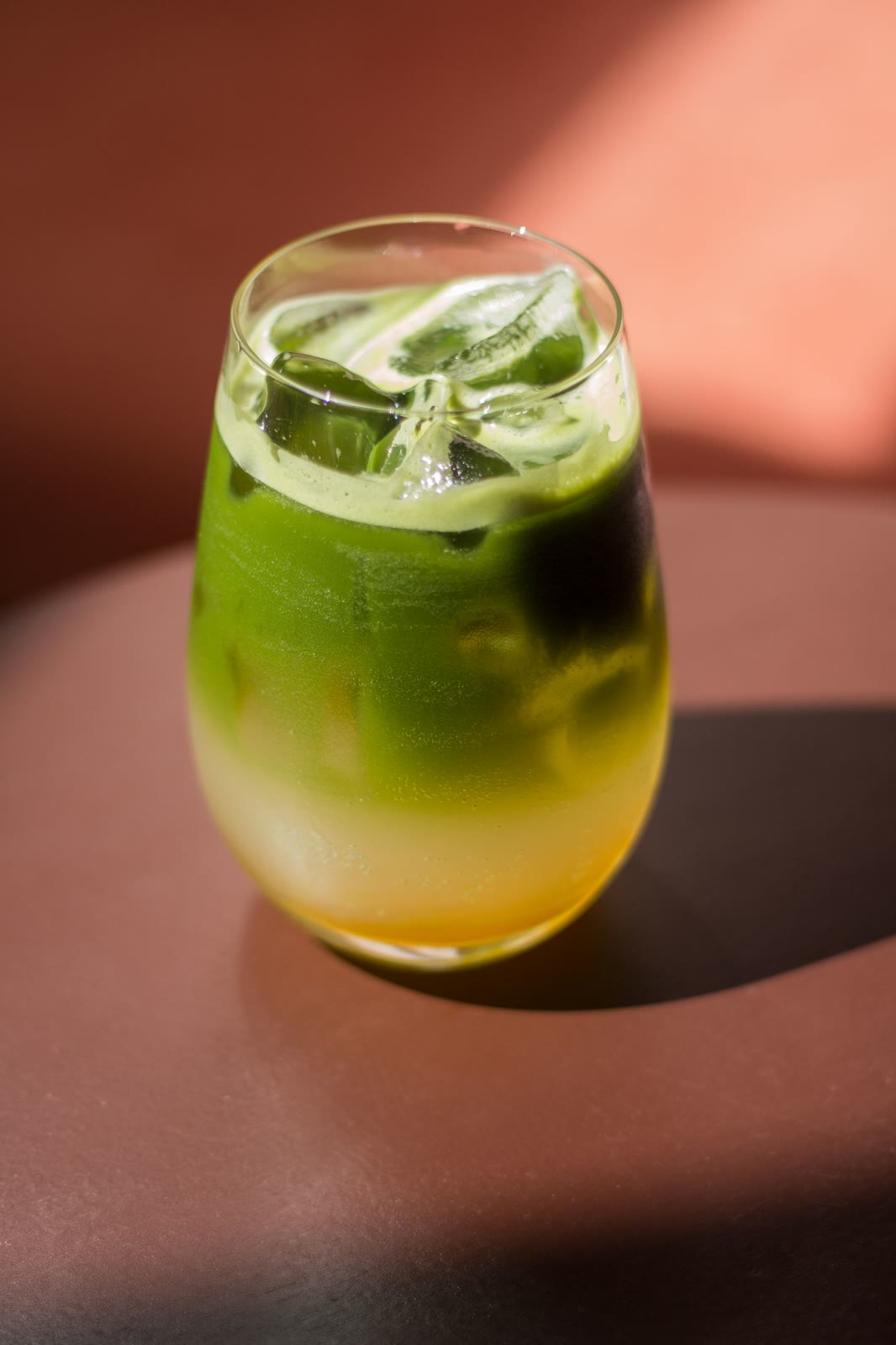 Iced matcha in a glass on a sunny terracotta table