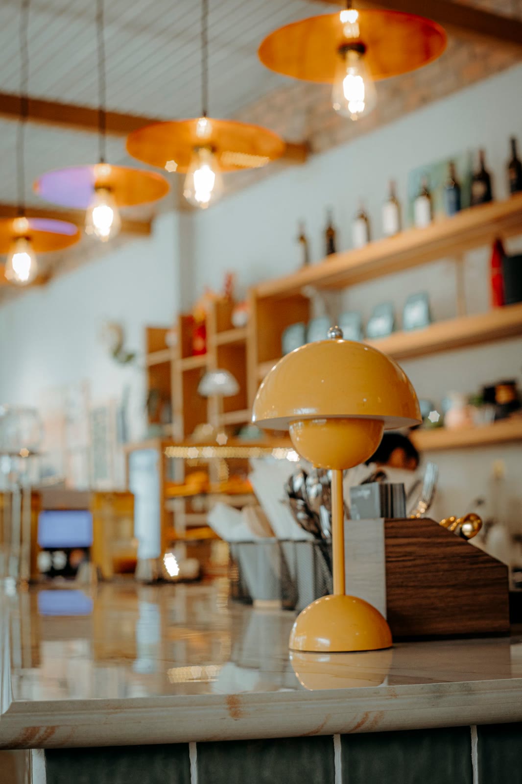 Café bar with amber pendant lamps and a mustard table lamp