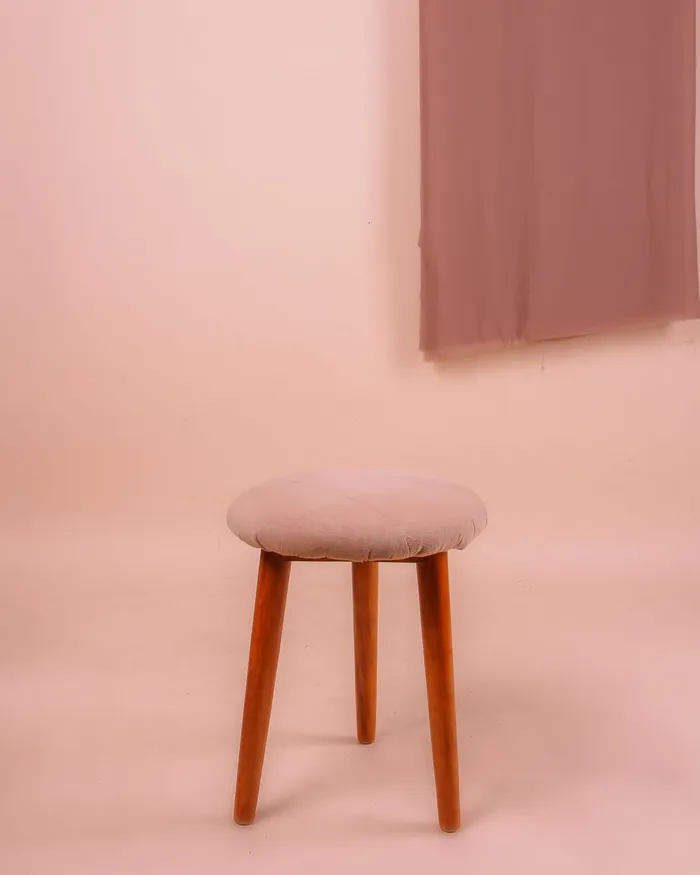 Small stool with a pink upholstered seat