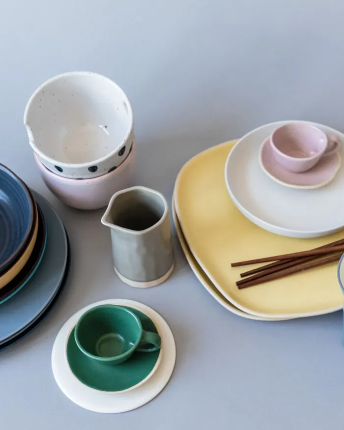 Plates, bowls, a jug and cups in ink, sun, blush and moss glazes