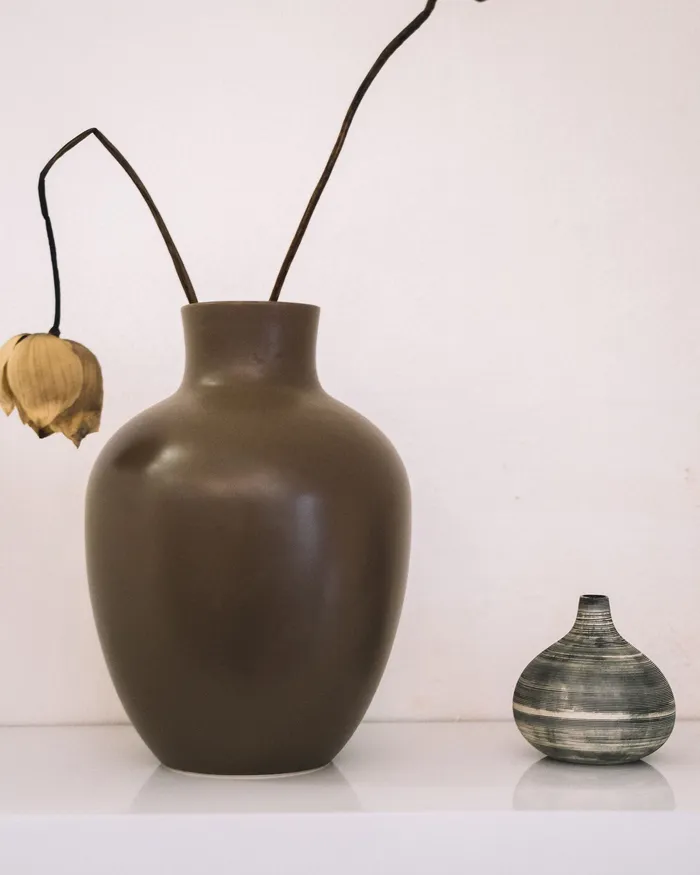 Brown stoneware vase with dried stems