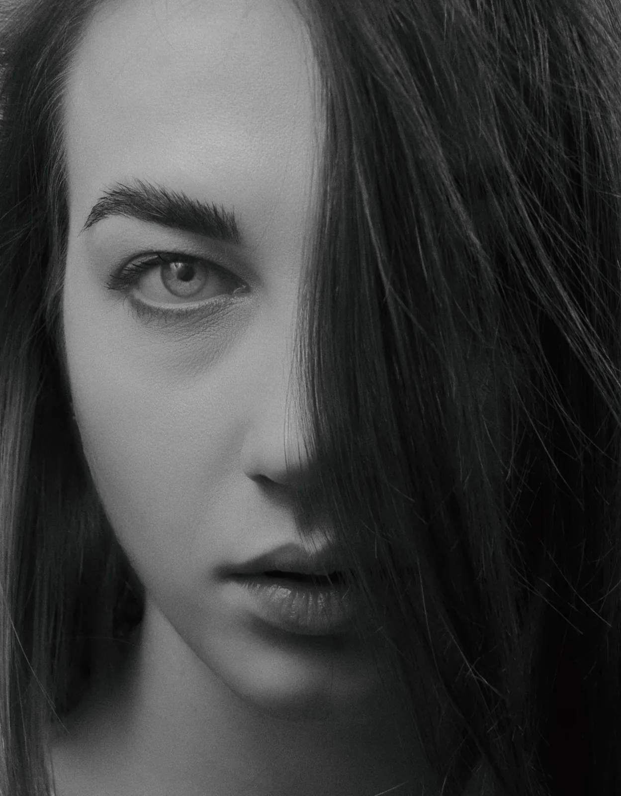 Black and white portrait of a woman with hair across one eye