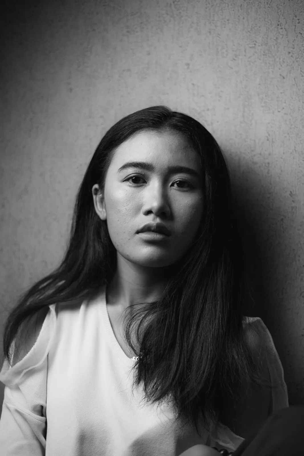 Portrait of a young woman against a white wall