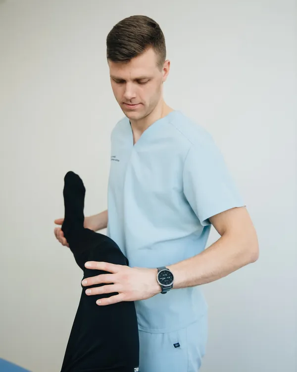 Therapist stretching a patient's raised leg