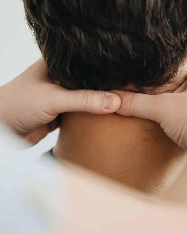 Therapist's hands treating a patient's neck