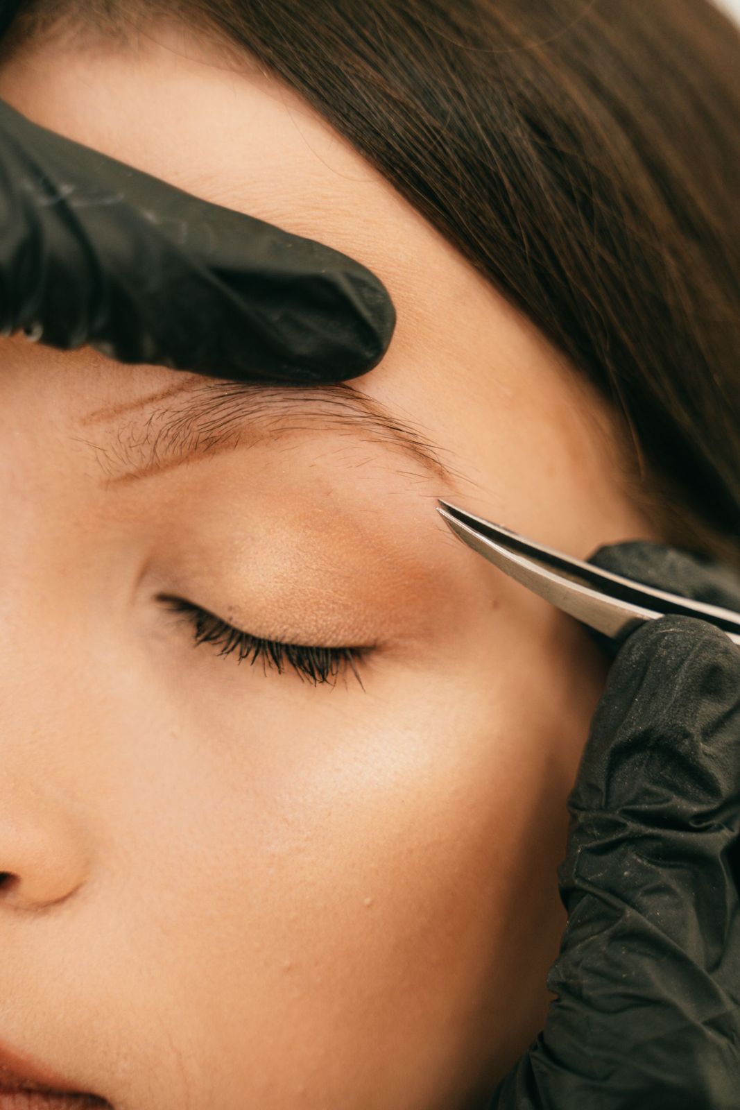 An artist maps a client's brow before any pigment goes in