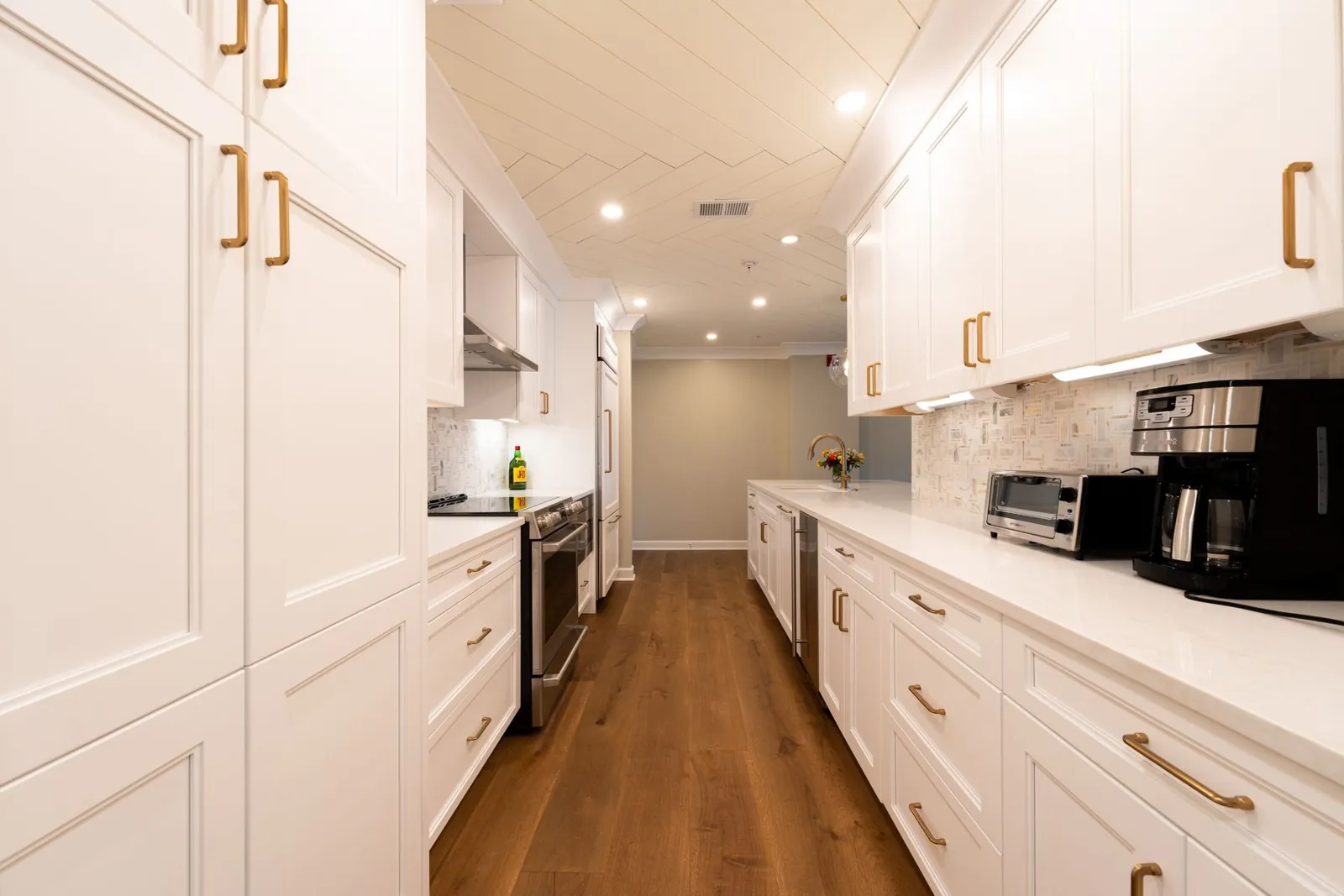 The finished kitchen with white cabinets and an oak floor
