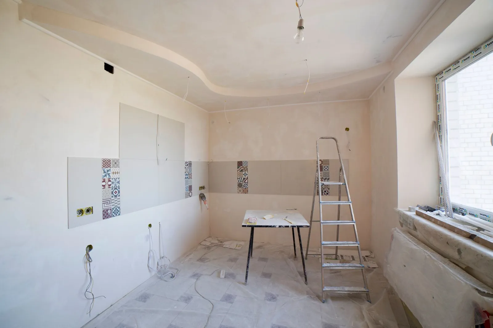 The kitchen during the strip-out, bare walls and loose wiring